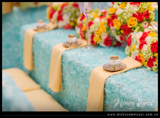 Bộ ấm chén màu đồng, kết hợp với khăn ăn trang trí một cách tự nhiên, đơn giản nhưng tôn lên nét đẹp và sự chỉn chu trong từng chi tiết. Việc chăm chút cho bàn uống nước của hai họ không chỉ thể hiện sự tôn trọng khách mời mà còn ghi dấu ấn đáng nhớ trong ngày vui của đôi uyên ương.